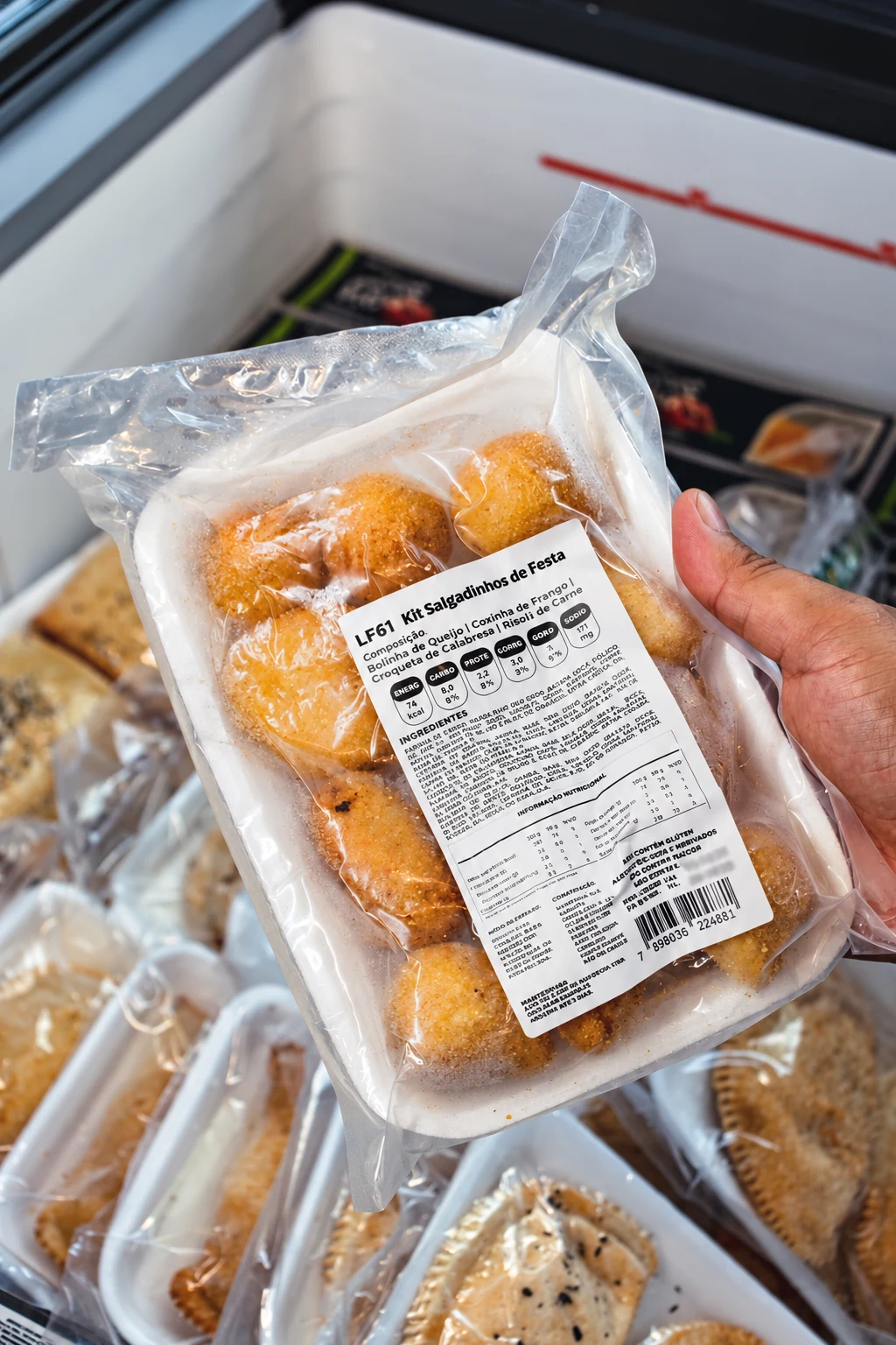 Kit de salgadinhos Nowheat nas mãos de um cliente, diante do freezer.